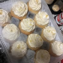 Tray of vanilla cupcakes with swirled whipped frosting