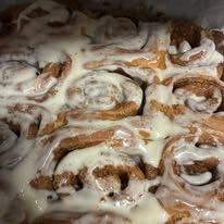 Pan of warm cinnamon rolls covered in cream cheese icing