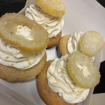 Lemon cupcakes topped with whipped frosting and candied lemon slices