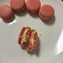 Pink strawberry macarons with cream filling on a plate