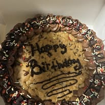 Happy Birthday chocolate-frosted cookie cake with sprinkles